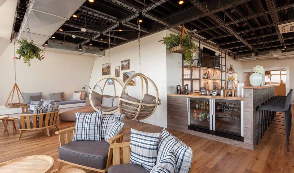 Modernly designed NIGHT.LOUNGE with hanging chairs, sofas and a welcoming atmosphere in the Wyn. on Sylt.