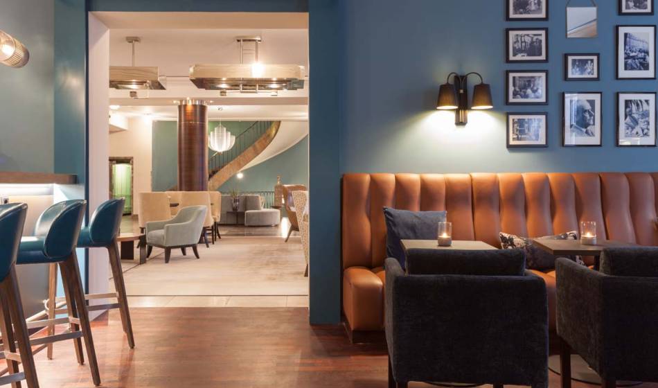 Stilvolle Sitzecke in der Bar des Hotel Elephant Weimar mit gepolsterten Ledersofas und gemütlicher Beleuchtung.