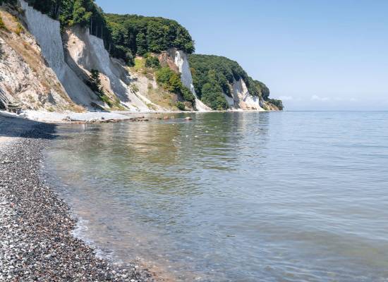 Kreidefelsen auf Rügen mit ruhigem Meer und klarem Himmel.