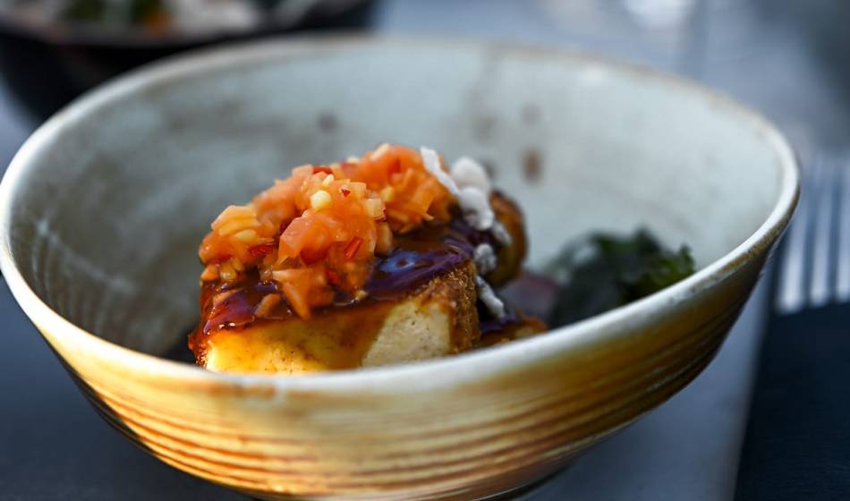 Bowl of fried dish, garnished with fresh toppings and aromatic sauce in #herrhoshi on the Darß.
