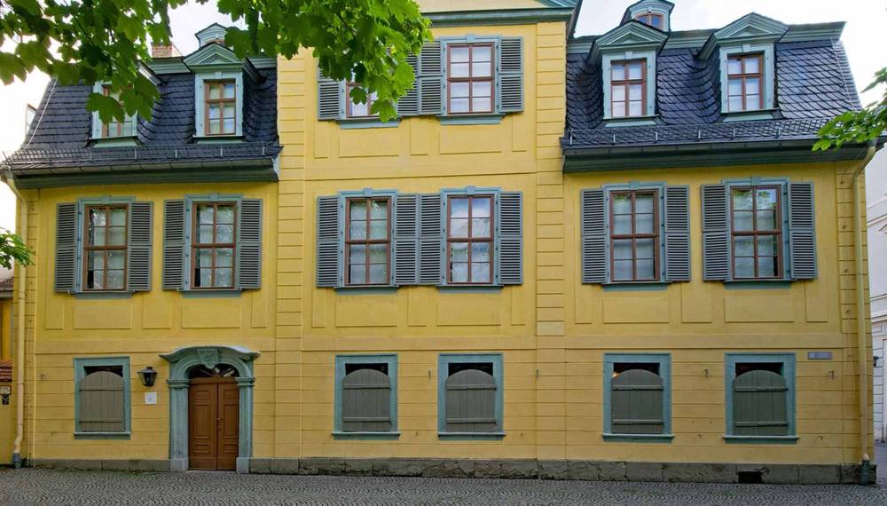 Schillerhaus in Weimar mit gelber Fassade, grünen Fensterläden und historischem Eingangsportal in der Altstadt.