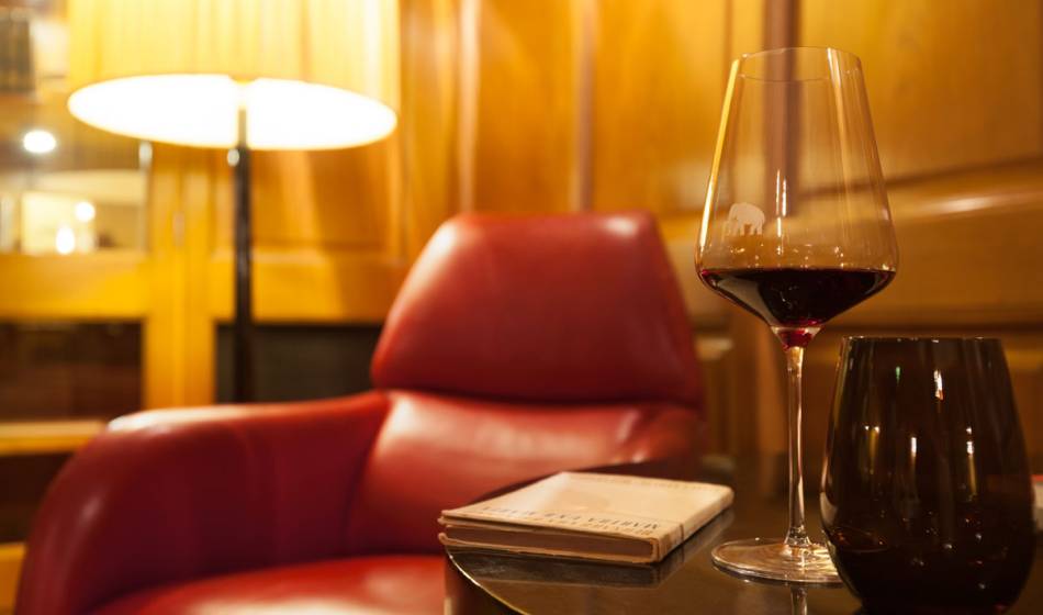 Gemütlicher Sessel mit Rotwein und Buch in der Hotel Elephant Weimar  Bibliothek