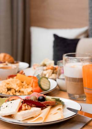 Aufnahme eines Frühstückstisches im Koopmanns in Göhren mit Saft, Milchkaffee, Eier, verschiedenden Backwaren, Obst und verschiedenen Aufschnitt.