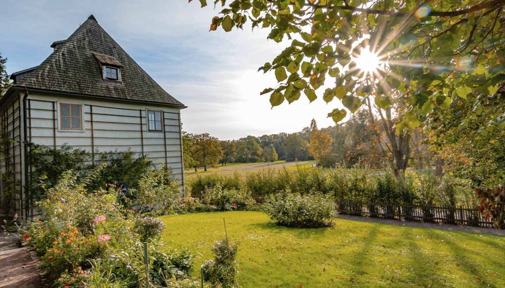 Goethes Gartenhaus im Park an der Ilm in Weimar mit Garten, Wiese und Bäumen an einem sonnigen Tag.