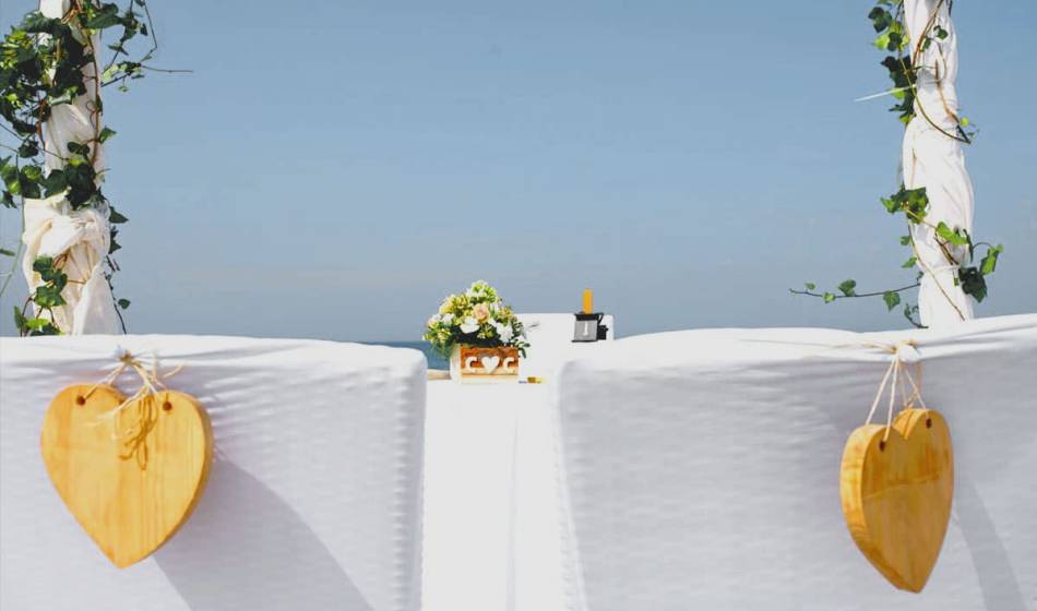 Two decorated chairs with wooden hearts and floral decorations for a beach wedding in the Hotel Künstlerquartier Seezeichen.