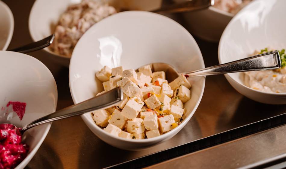 White bowl with diced sheep's cheese and herbs in the buffet area of ​​Café #fraukorn in Ahrenshoop.