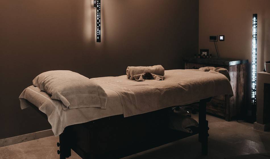 Behandlungsraum mit einer Massageliege, gedämpftem Licht und entspannter Atmosphäre im Barefoot Hotel Mallorca.