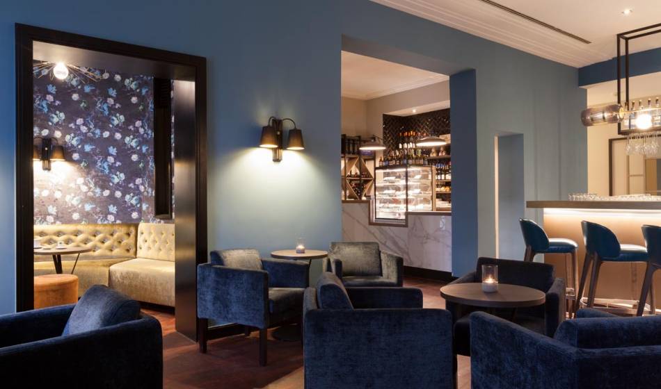 Stilvolle Bar im Hotel Elephant Weimar mit verschiedenen Lounge-Bereichen und moderner, blauer Dekoration.