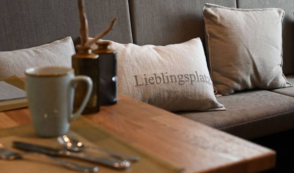Cozy seating area at the Strandläufer on Rügen with decorative cushions and inviting table settings.
