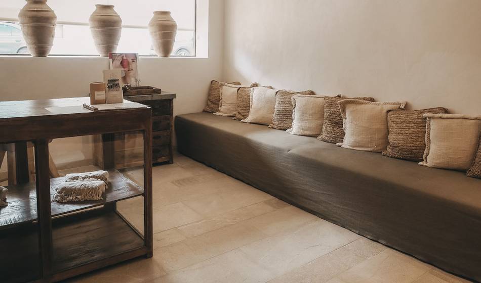 Gemütlicher Lounge-Bereich mit mehreren Kissen und einem kleinen Tisch im Wellnessbereich des Barefoot Hotels Mallorca.