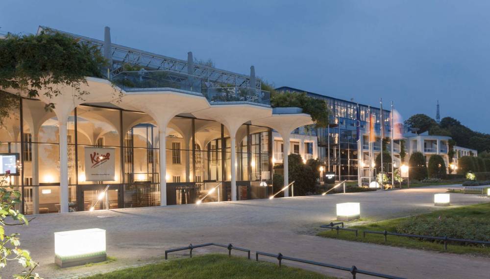 Außenansicht des Hotel Kaiserhof Heringsdorf mit Eingangsbereich und angrenzendem Glasforum des Kaiserbädersaals in der Abenddämmerung
