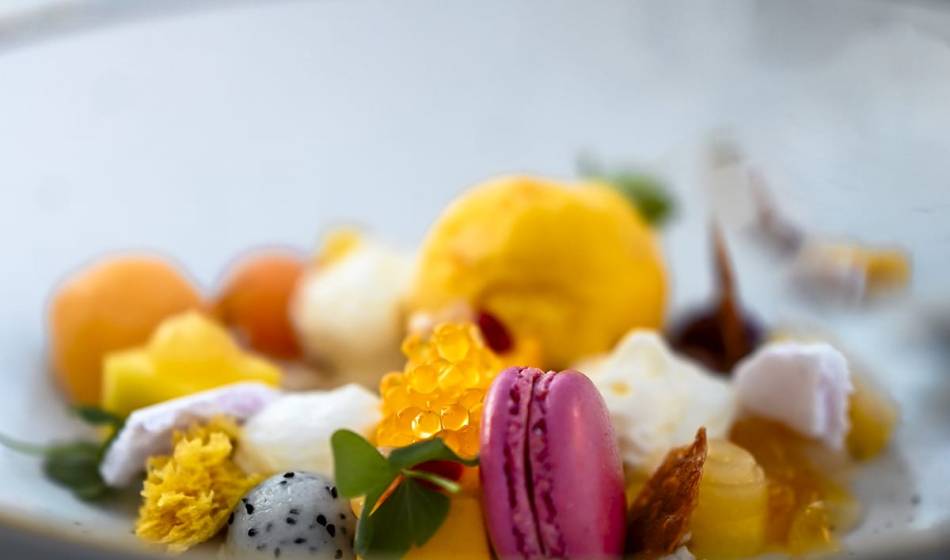 Dessert with colorful fruits, macaron, edible flowers and small cream toppings, decoratively arranged in #herhoshi.