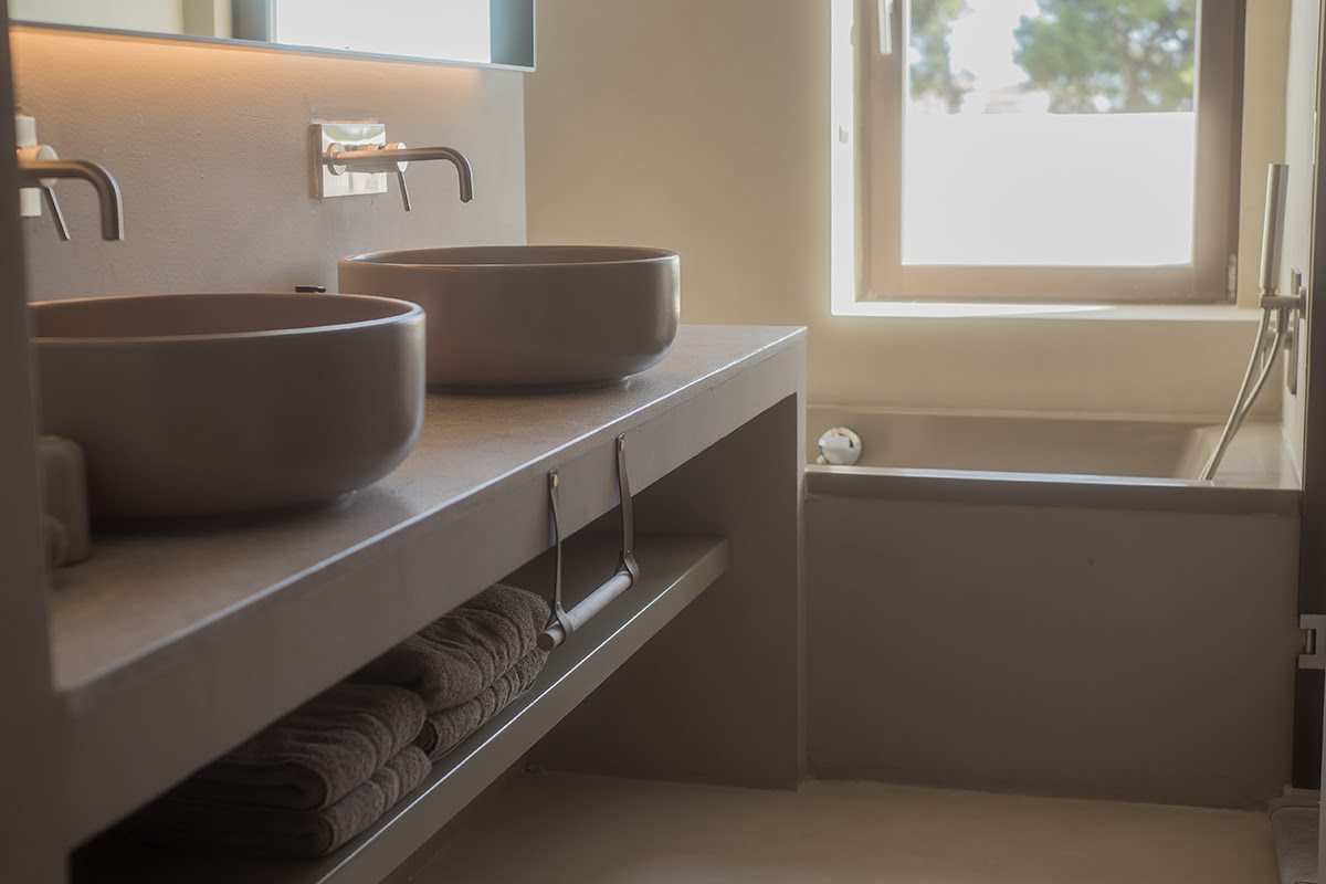 Helles Badezimmer mit moderner Badewanne und Doppelwaschbecken in der Suite des Barefoot Hotels Mallorca.