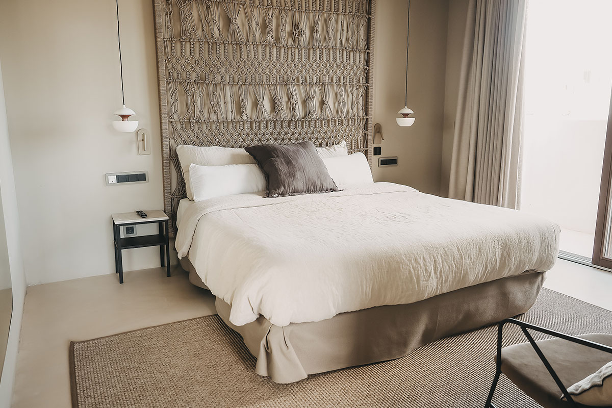 Schlafbereich der Suite im Barefoot Hotel Mallorca mit modernem Design, gemütlichem Bett und stilvoller Wandgestaltung.