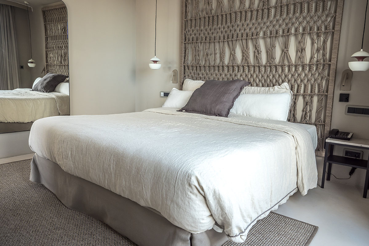 Schlafzimmer mit einladendem Bett und harmonischen Details in der Suite des Barefoot Hotels Mallorca.