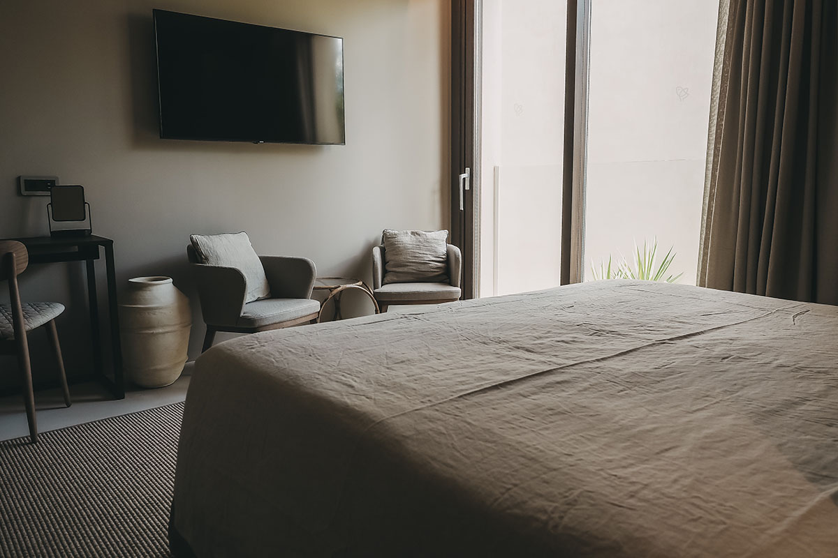 Moderner Sitzbereich mit hellen Sesseln und natürlicher Dekoration im Zimmer Puro des Barefoot Hotel Mallorca.