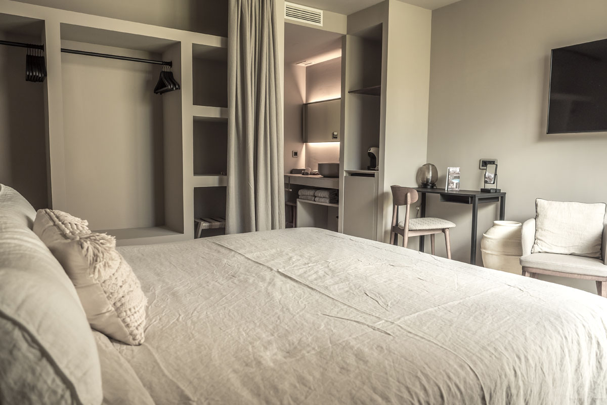 Gemütliches Puro Hotelzimmer im Boho-Stil mit großem Bett, offener Einrichtung und Schreibtisch im Barefoot Hotel.