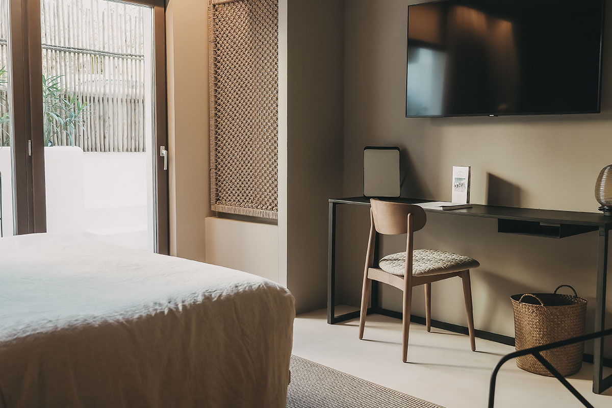 Moderna zona de trabajo en la habitación Pueblo del Barefoot Hotel Mallorca con escritorio y silla de madera.