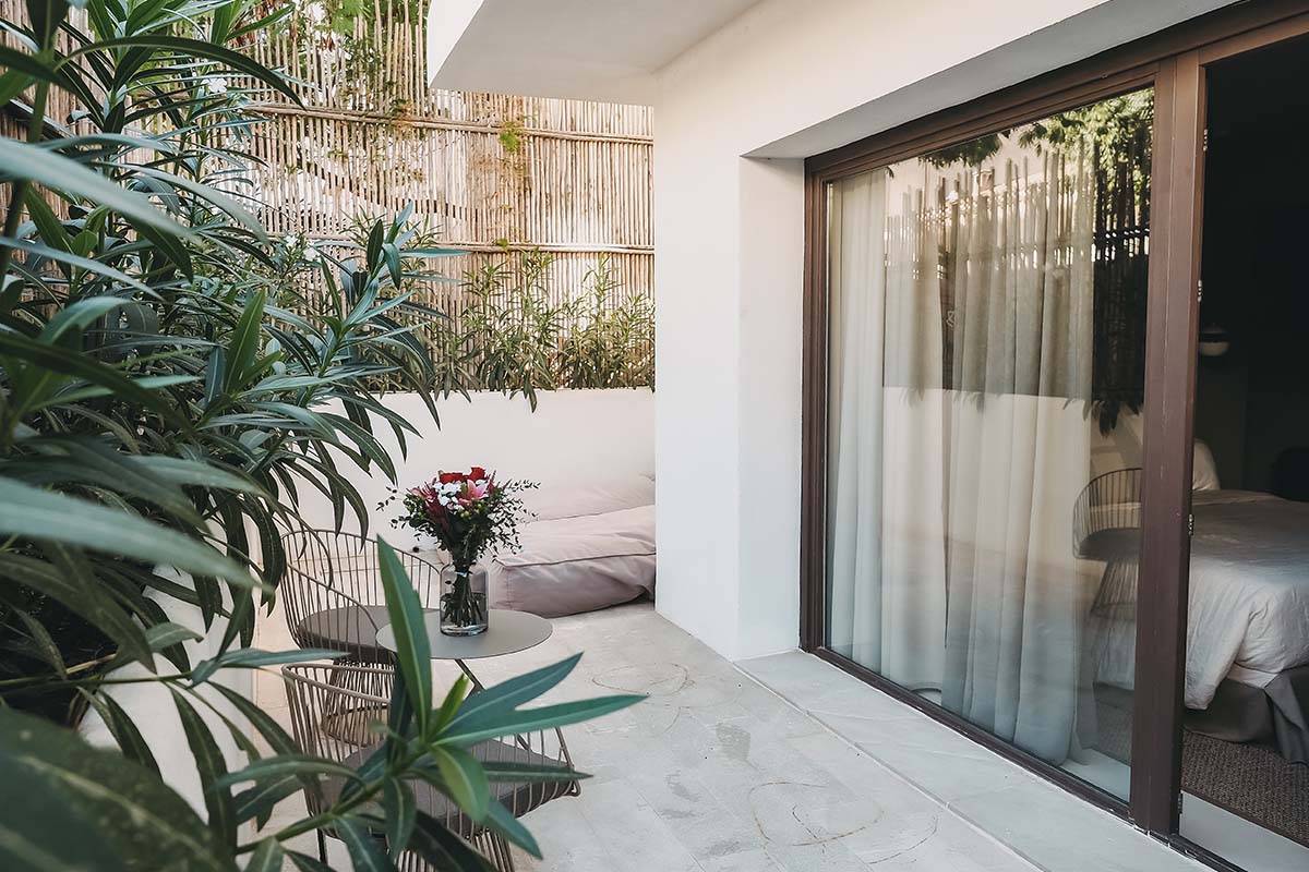 Terraza privada en la habitación Pueblo del Barefoot Hotel Mallorca con decoración, flores y mucho verde.