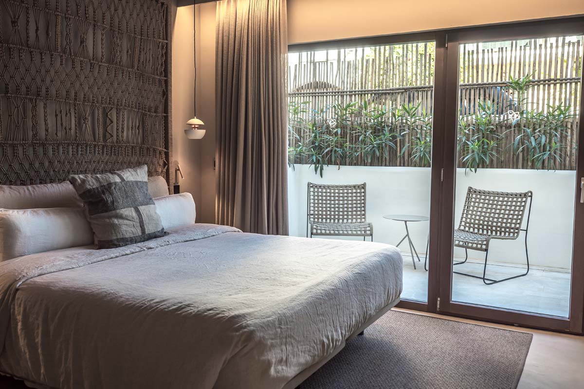 Moderna habitación pueblo en el Barefoot Hotel Mallorca con cama doble, grandes ventanales y acceso a la terraza privada.