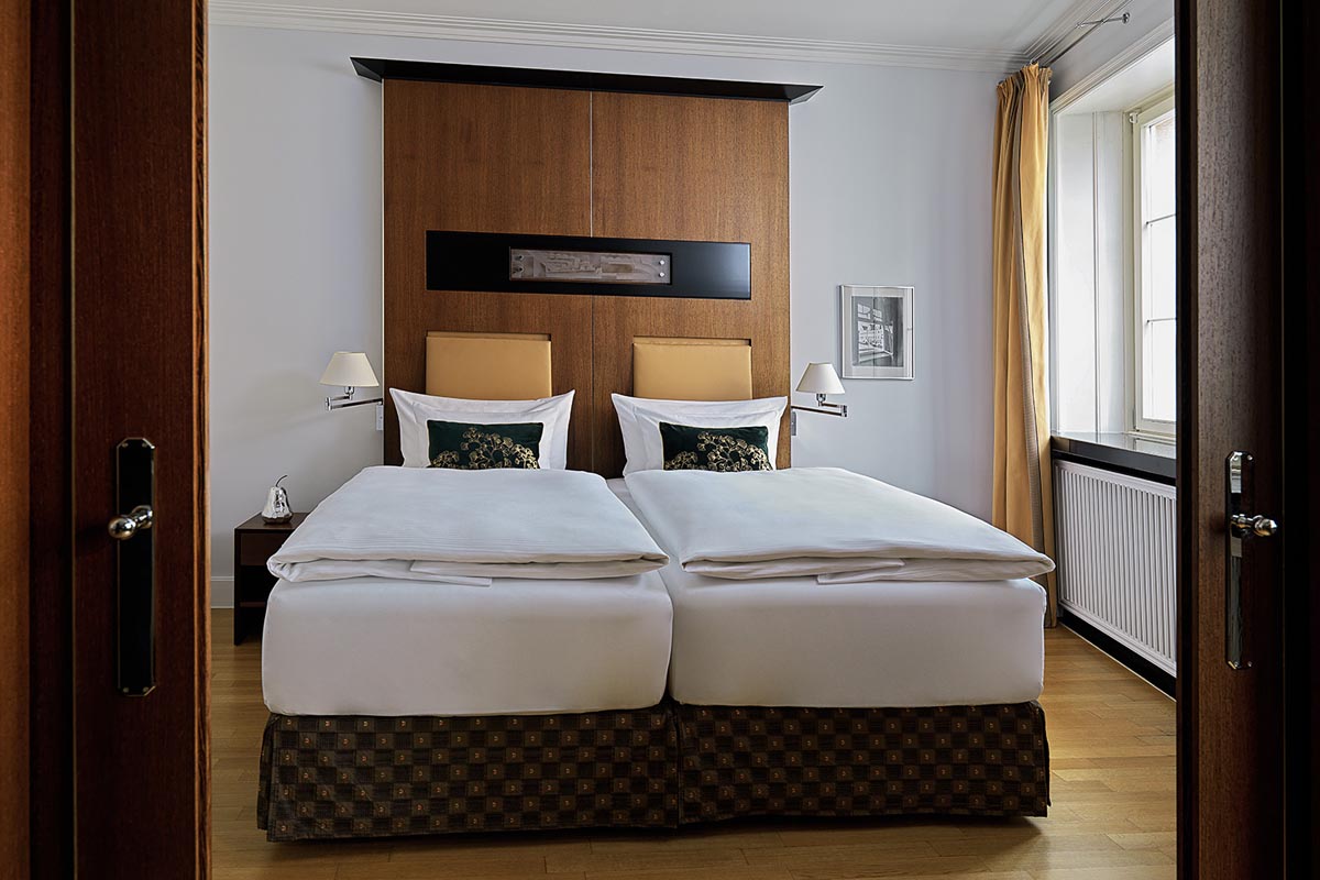 Comfortable double bed in the bedroom of the Walter-Gropius-Suite in the Hotel Elephant Weimar with elegant furnishings.