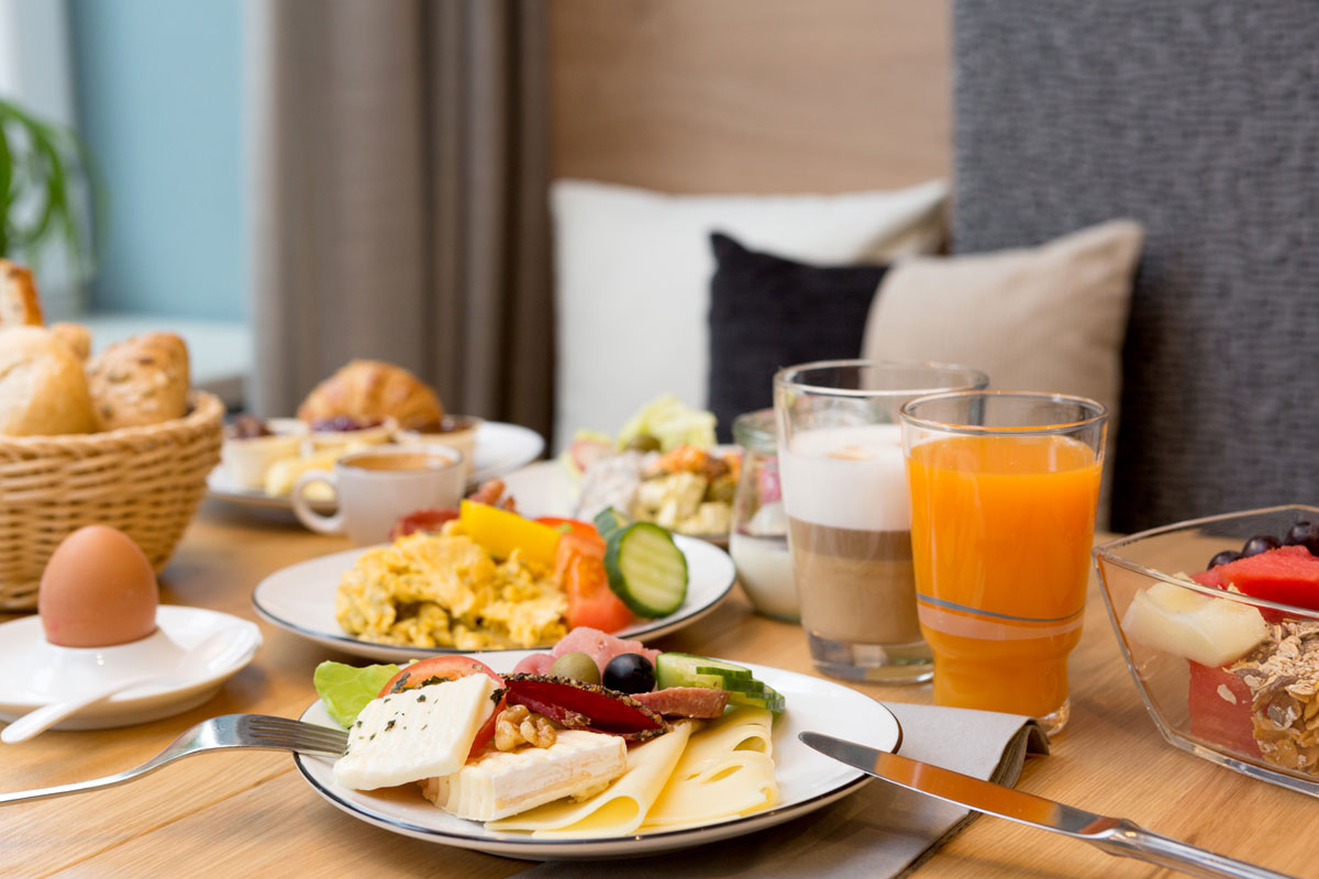 Frühstückstisch mit leckeren Spezialitäten, Orangensaft und Kaffee im Koopmanns Hotel &amp; Lädchen auf Rügen.