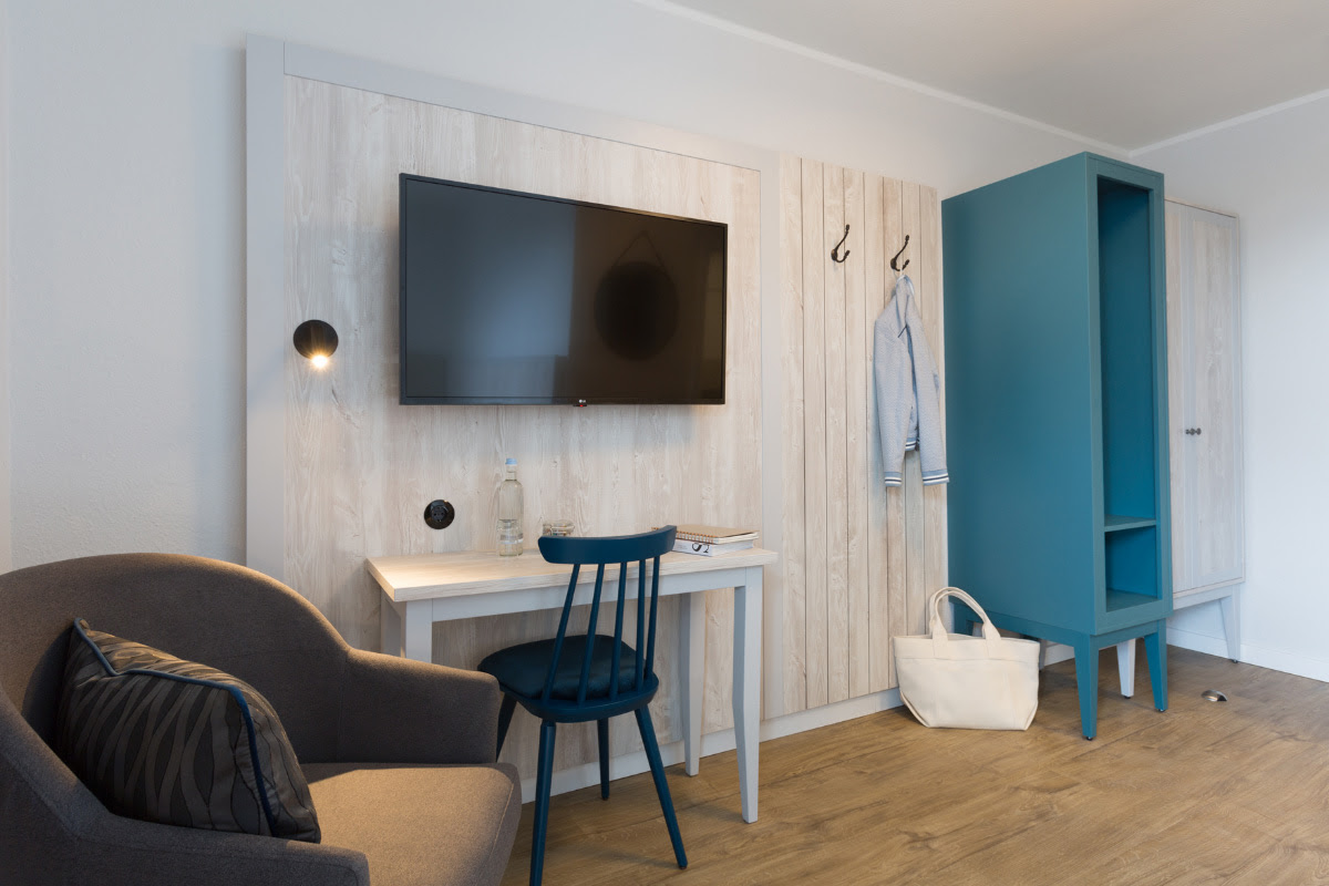 Einzelzimmer mit modernem Sitzbereich im skandinavischen Stil im Koopmanns Hotel &amp; Lädchen.
