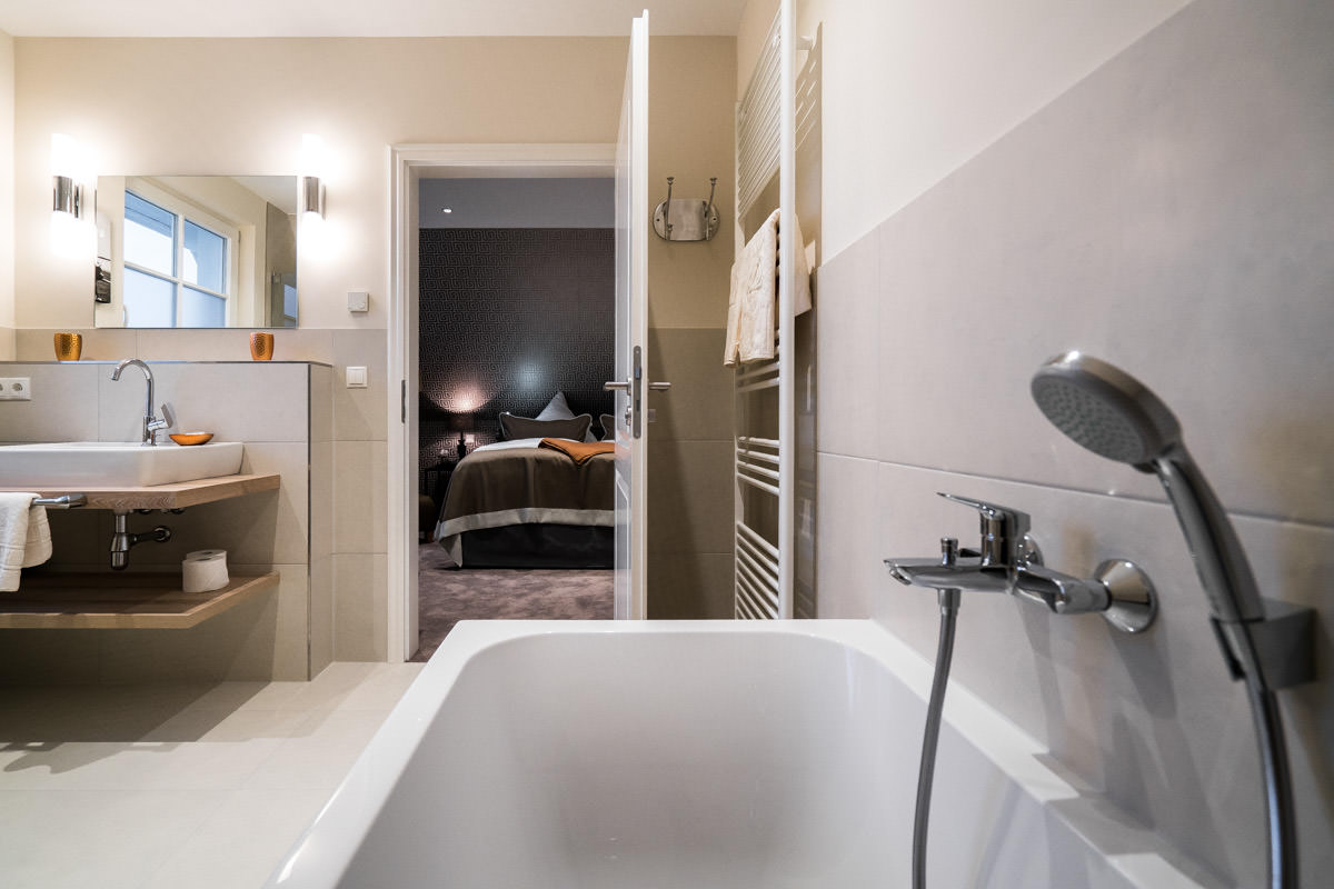 Modernes Ensuite-Badezimmer mit Badewanne für Erholung im Ferienhaus Ostseeperle des Hotel Künstlerquartier Seezeichen.