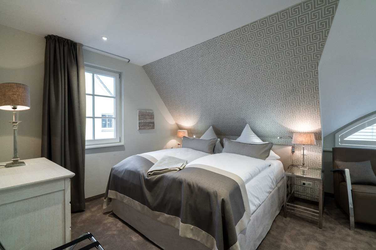 Komfortables Schlafzimmer mit großem Doppelbett im Ferienhaus Ostseeperle des Hotel Künstlerquartier Seezeichen.
