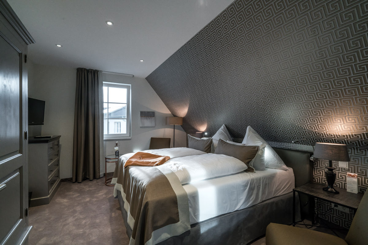 Gemütliches Schlafzimmer mit modernem Design und Doppelbett im Ferienhaus Ostseeperle des Hotel Künstlerquartier Seezeichen.