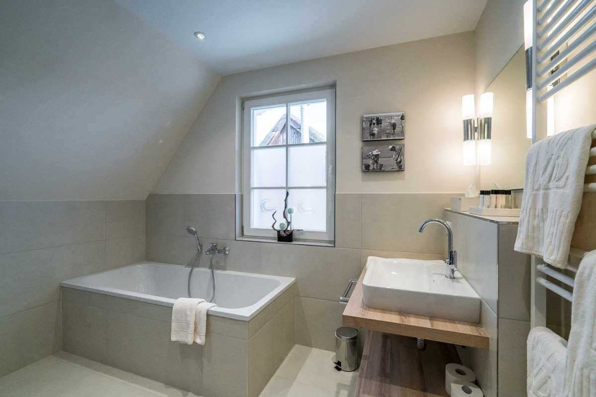 Modernes Badezimmer mit Badewanne im Ferienhaus Seewind des Hotel Künstlerquartier Seezeichen.