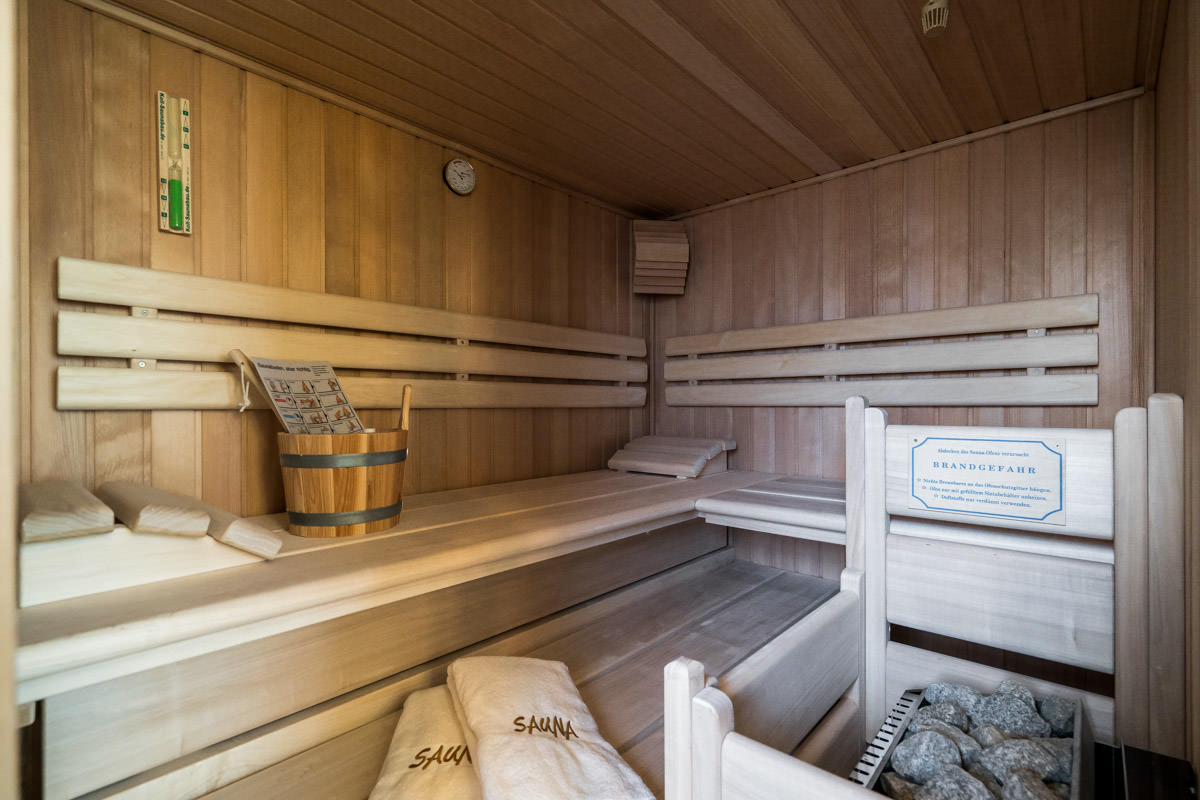 Holzsauna mit Sitzbänken und Handtüchern, ideal zum Entspannen im Ferienhaus Seewind des Hotel Künstlerquartier Seezeichen.