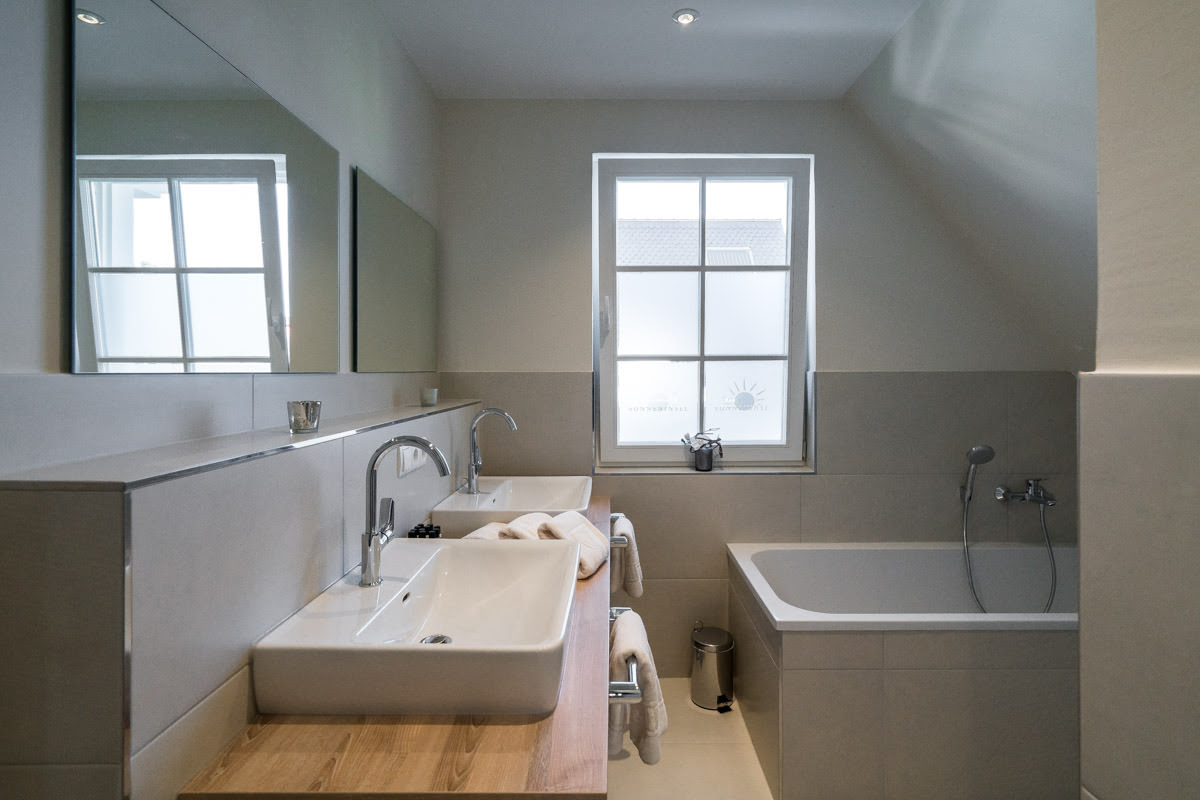 Lichtdurchflutetes Bad mit Badewanne, moderner Einrichtung und Komfort im Ferienhaus Sonneninsel des Hotel Seezeichen.