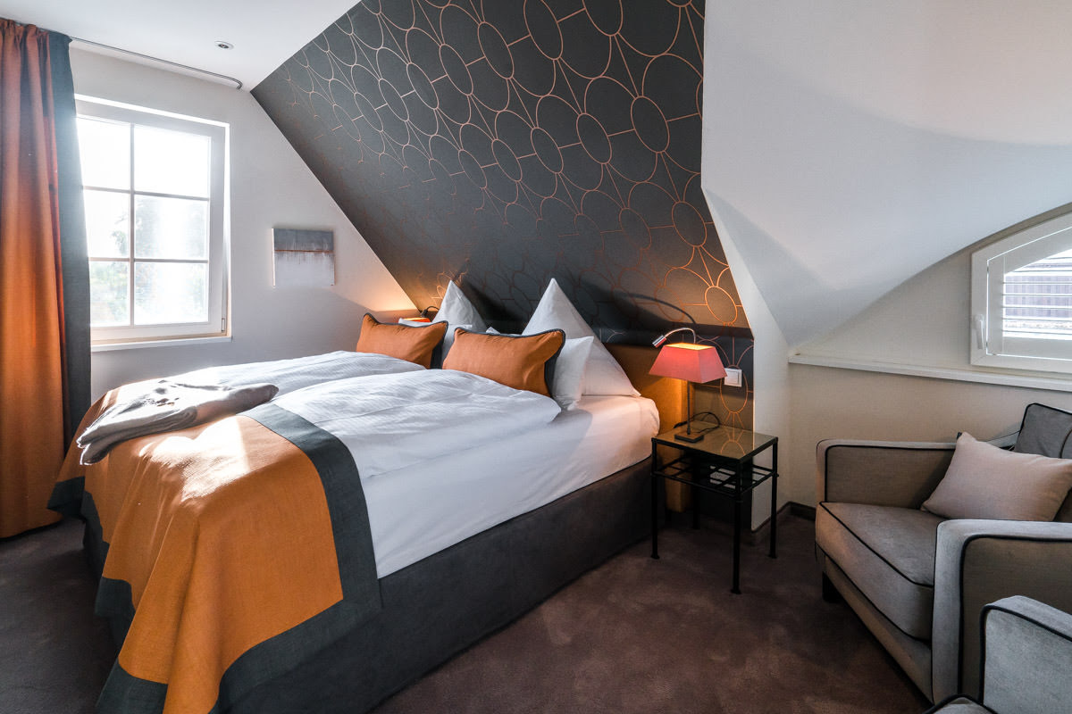 Gemütliches Bett im Ferienhaus Sonneninsel des Hotel Künstlerquartier Seezeichen mit hochwertiger Bettwäsche.