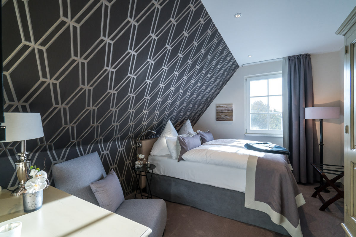 Gemütliches Schlafzimmer im Ferienhaus Sonneninsel, Teil des Hotel Künstlerquartier Seezeichen, mit großem Bett.