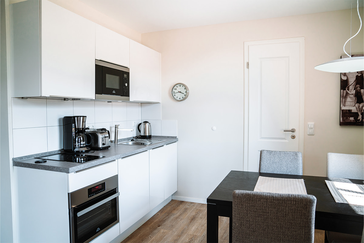 Helle, voll ausgestattete Küchenzeile in der Ferienwohnung Dünenpark des Hotel Künstlerquartier Seezeichen.