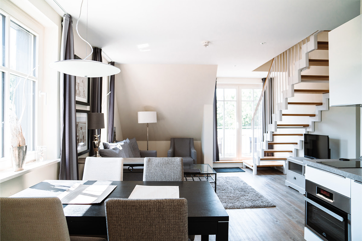 Elegantes Interieur der Ferienwohnung Dünenpark mit modernem Wohn- und Essbereich, Teil des Hotel Künstlerquartier Seezeichen.
