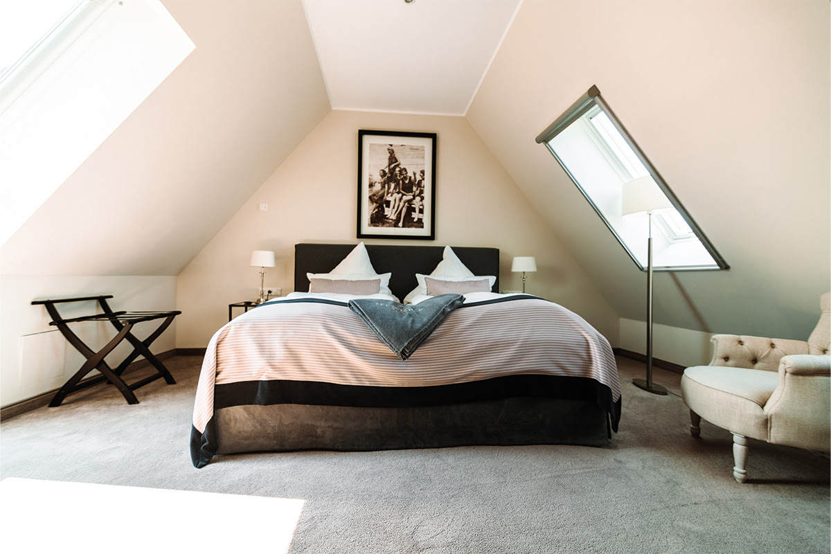 Helles Schlafzimmer in der Ferienwohnung Strandblick im Hotel Künstlerquartier Seezeichen mit Doppelbett und viel Tageslicht.