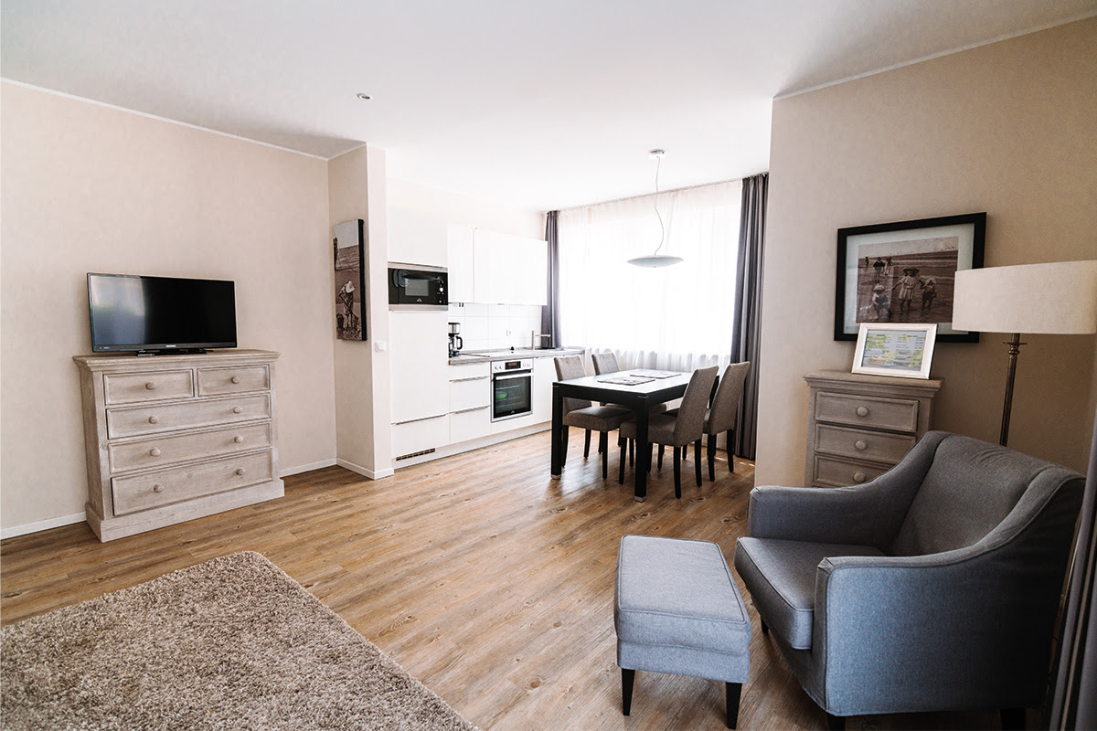 Moderne Ferienwohnung Stranddistel mit Essbereich, offener Küche und stilvollen Möbeln im Hotel Künstlerquartier Seezeichen.