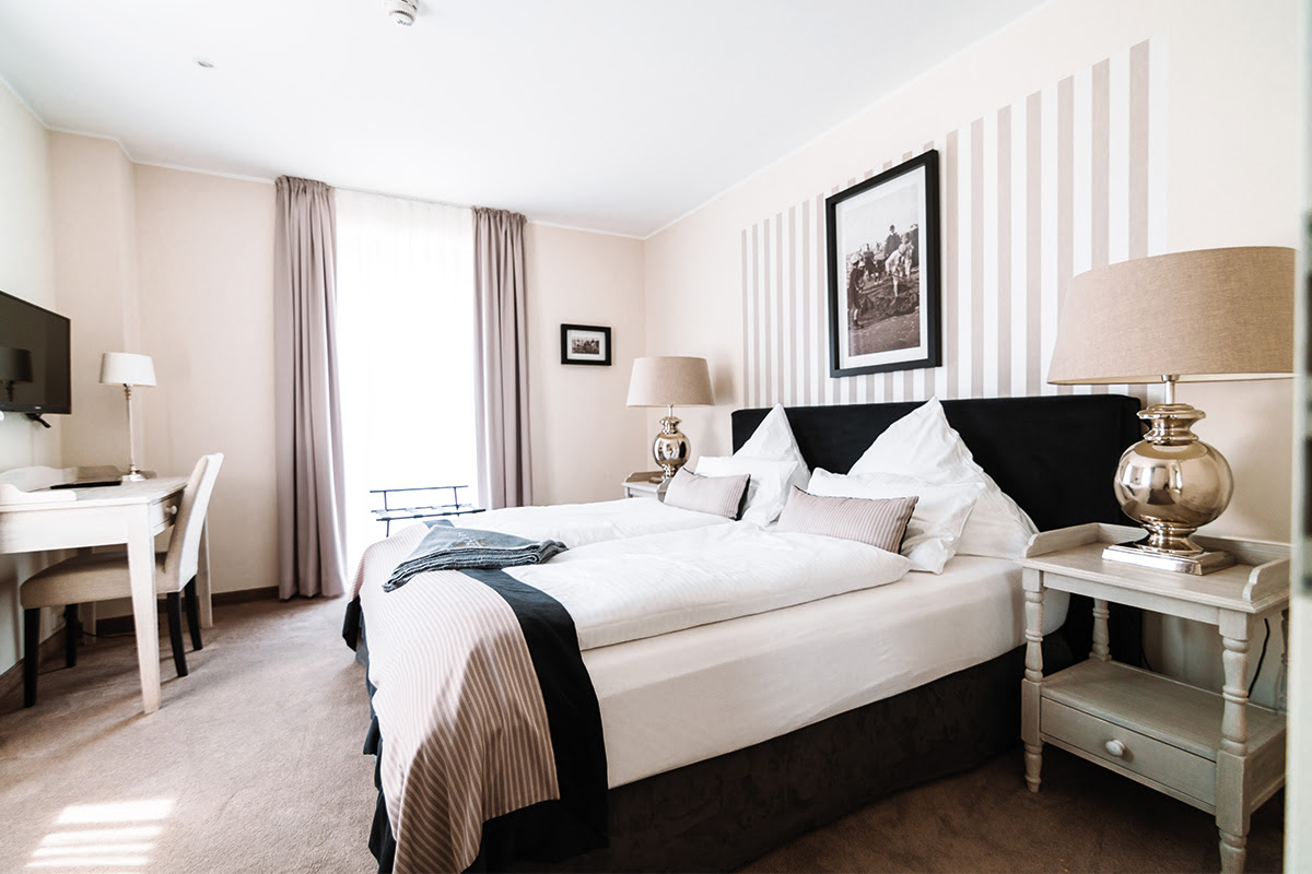 Helles Schlafzimmer der Ferienwohnung Stranddistel im Hotel Künstlerquartier Seezeichen mit gemütlichem Doppelbett.
