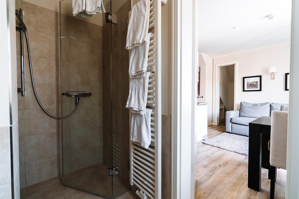 Moderne Glasdusche im Bad der Ferienwohnung Stranddüne im Hotel Künstlerquartier Seezeichen in Ahrenshoop.