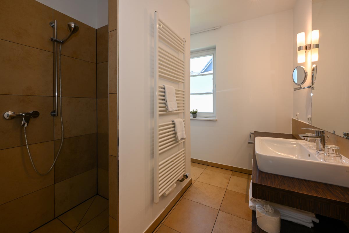 Großes Badezimmer mit Dusche und Tageslicht in der Ferienwohnung Seestern im Hotel Künstlerquartier Seezeichen.