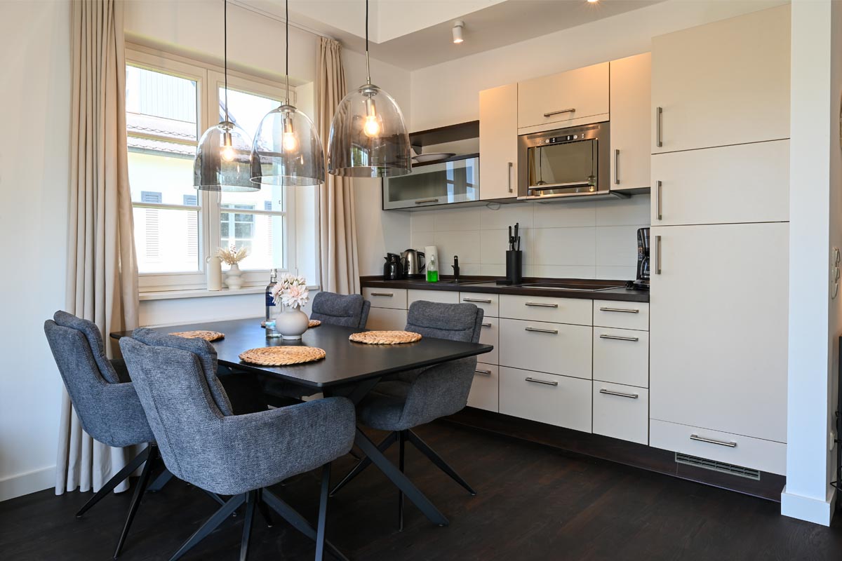 Offene Küche mit moderner Ausstattung und Essbereich in der Ferienwohnung Seestern im Hotel Künstlerquartier Seezeichen.