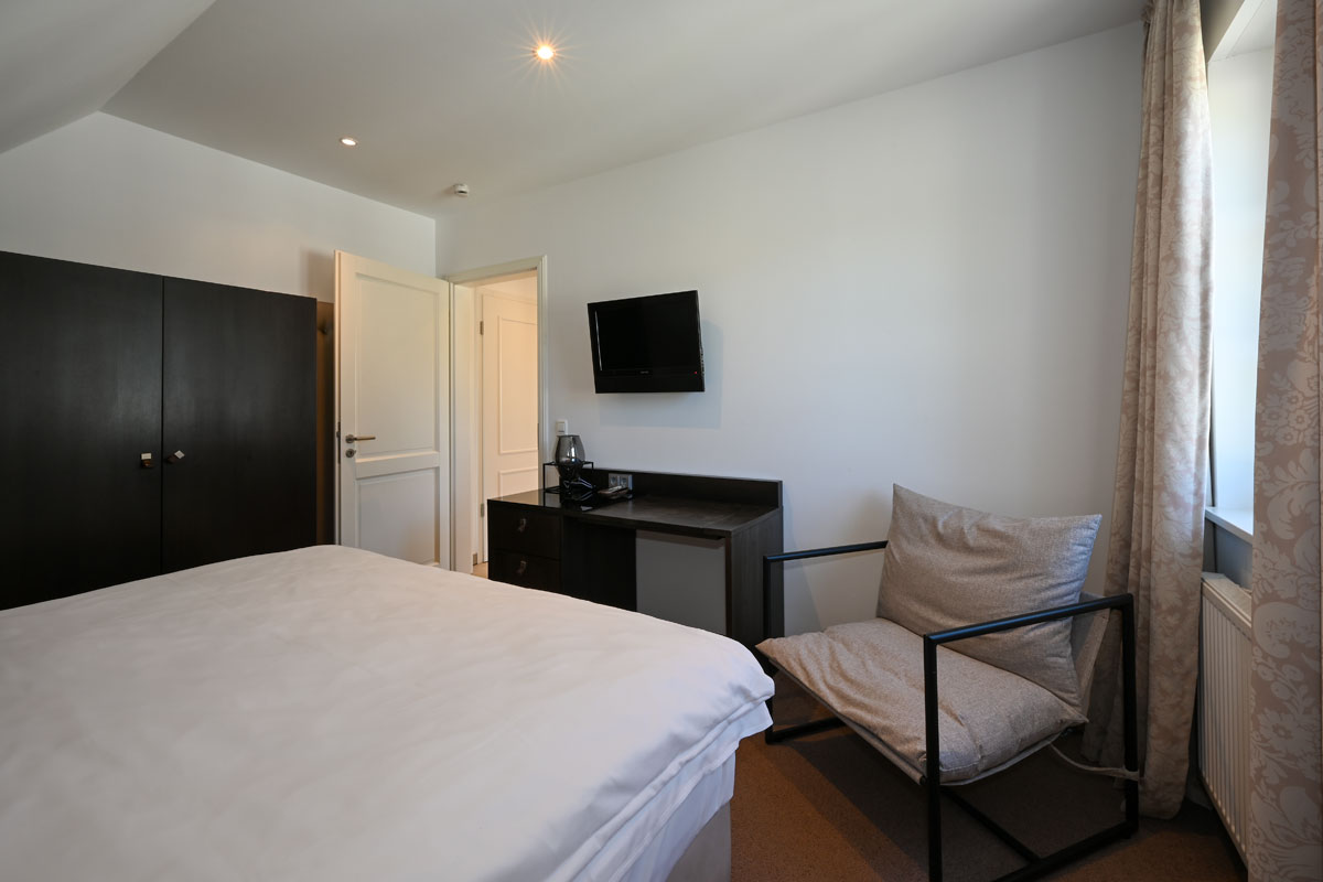 Modernes Schlafzimmer mit Doppelbett und großem Kleiderschrank in der Ferienwohnung Seestern im Hotel Künstlerquartier Seezeichen.