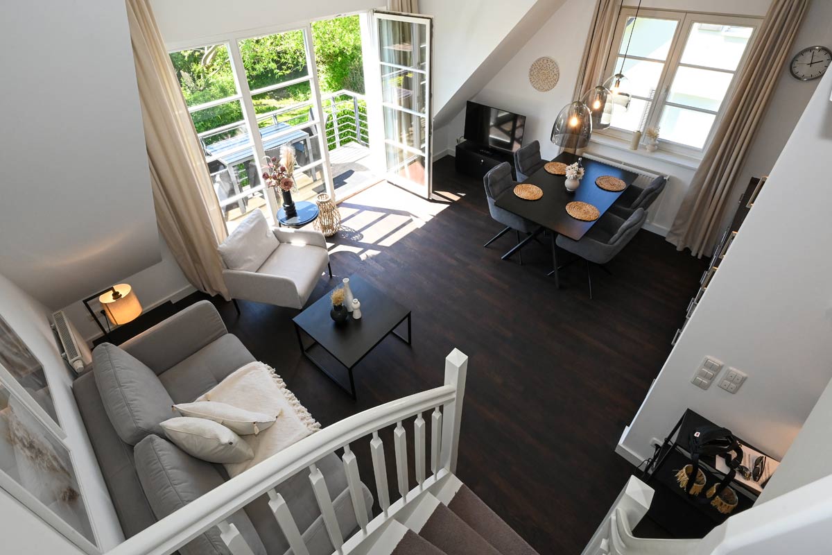 Überblick über den Wohnbereich der Ferienwohnung Seestern im Hotel Künstlerquartier Seezeichen mit moderner Einrichtung.