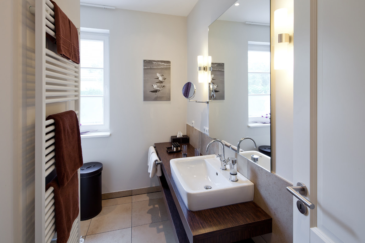 Helles Badezimmer mit viel Stauraum der Ferienwohnung Strandmöwe im Hotel Künstlerquartier Seezeichen.