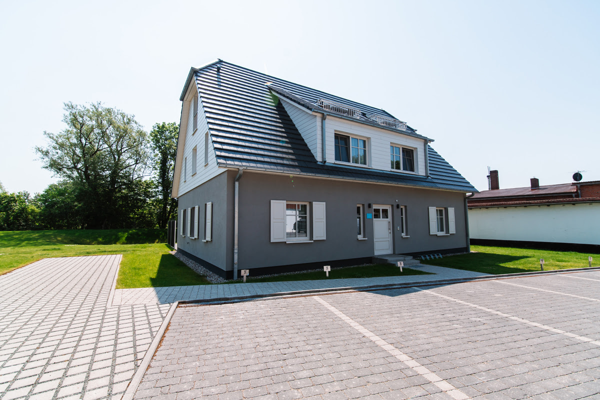 Außenansicht der modernen Strandvilla mit großzügigem Parkplatz und Garten, Teil des Hotels Künstlerquartier Seezeichen.
