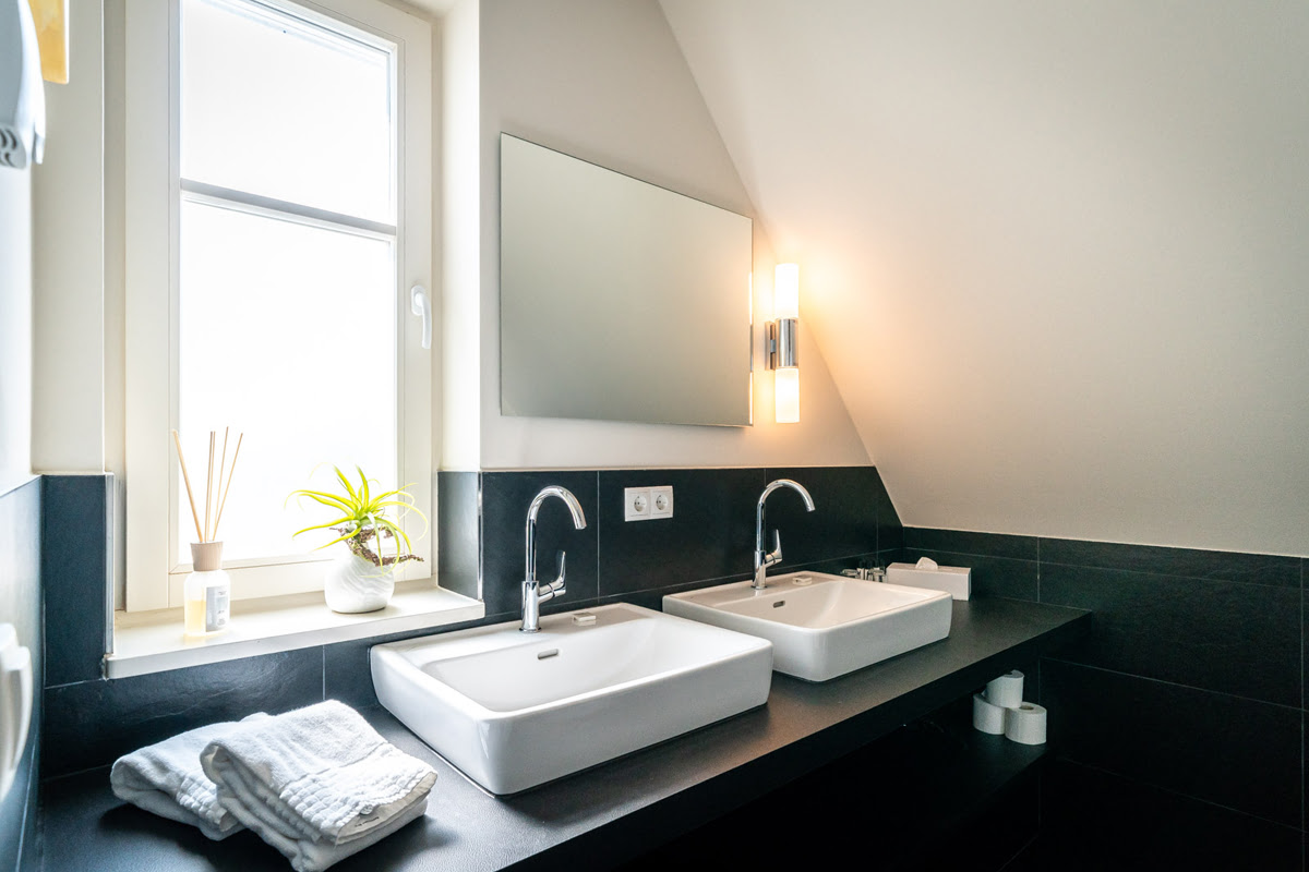 Modernes Bad in der Ferienwohnung Strandoase im Hotel Künstlerquarter Seezeichen mit luxuriösen Doppelwaschbecken.