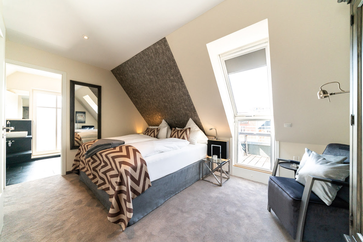 Helles Ensuite-Schlafzimmer mit Doppelbett der Ferienwohnung Strandoase im Hotel Künstlerquartier Seezeichen.