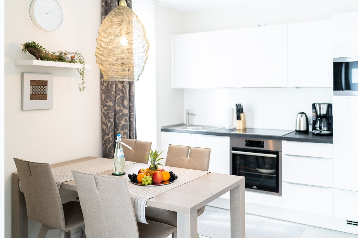 Küchenzeile mit Esstisch, Obstarrangement und moderner Einrichtung der Ferienwohnung Strandtraum im Künstlerquartier Seezeichen.